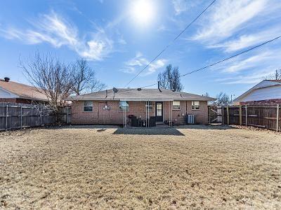 rear view of property featuring a yard and central air condition unit