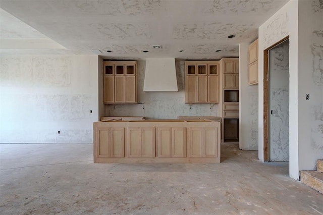 kitchen featuring light brown cabinetry and wall chimney range hood