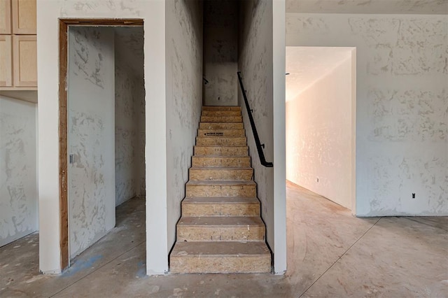 staircase featuring concrete floors