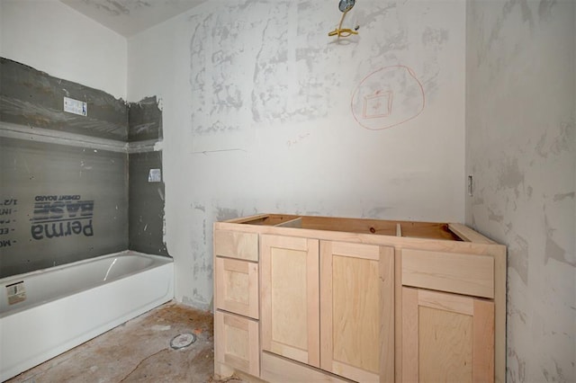 bathroom with concrete floors and a tub