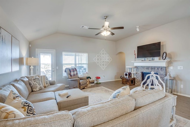 living room with ceiling fan, lofted ceiling, a fireplace, and hardwood / wood-style floors