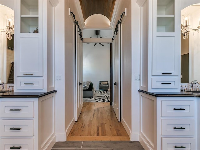 hallway with wood-type flooring and a barn door