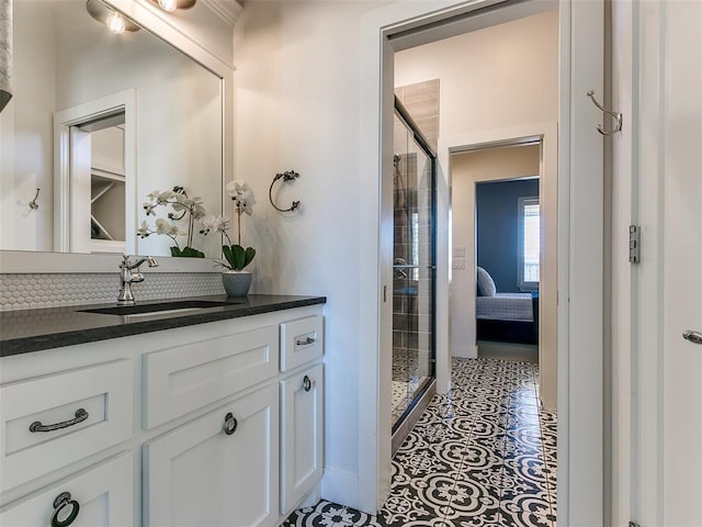 bathroom with vanity, a shower with shower door, and tile patterned floors