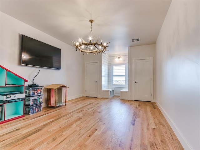 unfurnished living room with an inviting chandelier and hardwood / wood-style floors