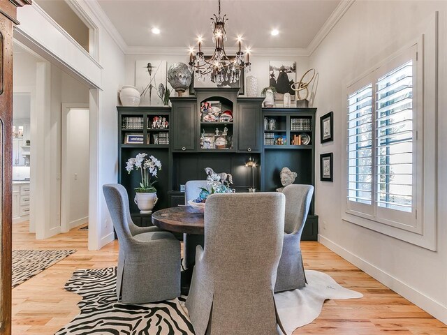 dining area with hardwood / wood-style flooring, crown molding, and a notable chandelier