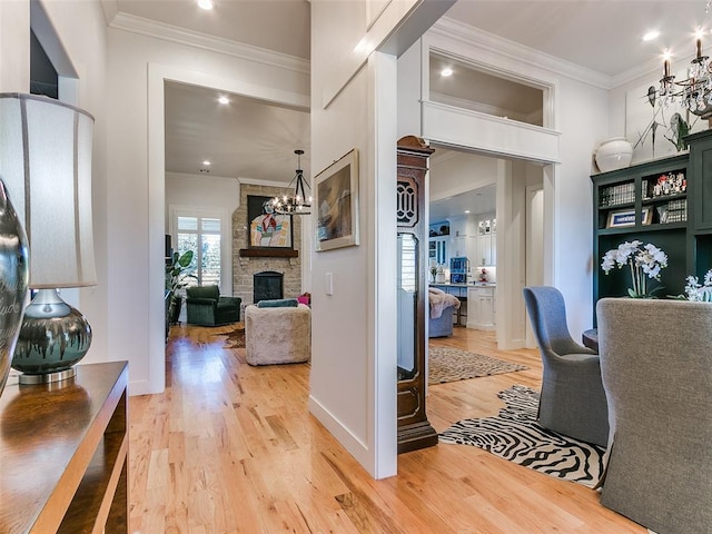 hall with crown molding, a chandelier, and light wood-type flooring