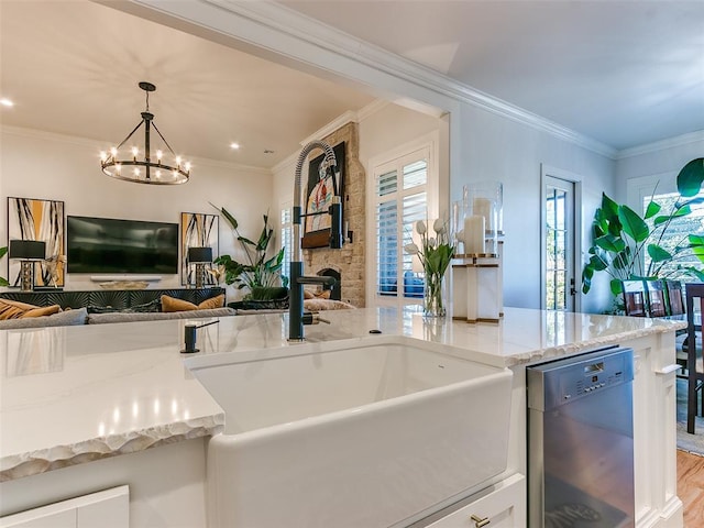 kitchen featuring a stone fireplace, sink, dishwasher, pendant lighting, and light stone countertops