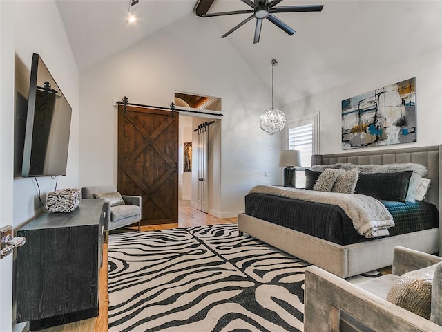 bedroom featuring an inviting chandelier, high vaulted ceiling, a barn door, and light wood-type flooring