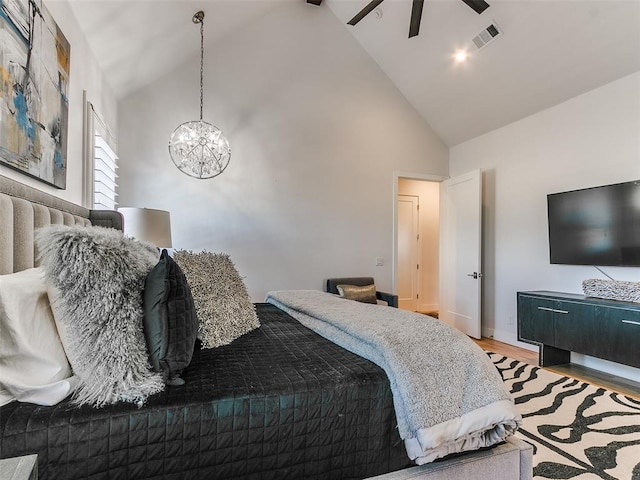 bedroom with high vaulted ceiling, an inviting chandelier, and light wood-type flooring