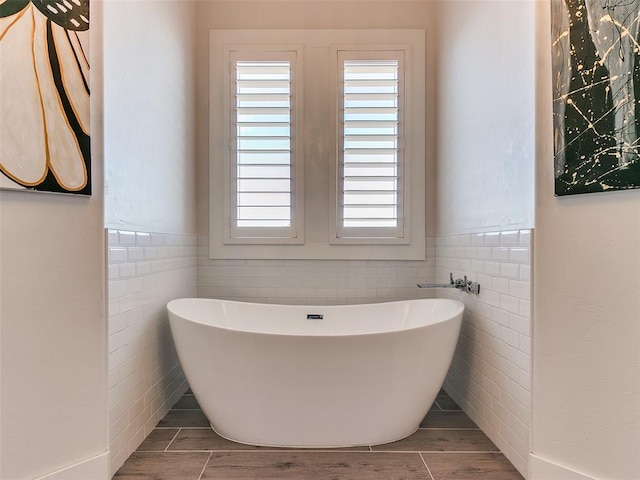 bathroom featuring tile walls and a bathtub