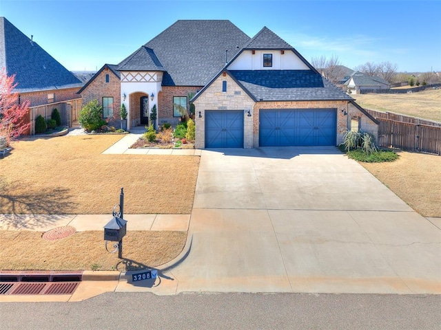 3208 Rolling Woods Dr, Norman, OK 73072 - view of front of property featuring a front yard, fence, stone siding, and driveway