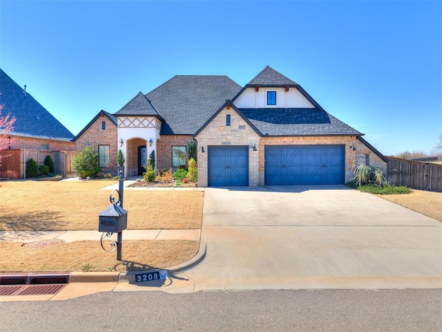 3208 Rolling Woods Dr, Norman, OK 73072 - view of front of house with a shingled roof, fence, concrete driveway, stone siding, and an attached garage