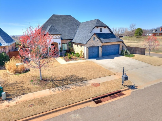 3208 Rolling Woods Dr, Norman, OK 73072 - french provincial home featuring concrete driveway, fence, stone siding, and a shingled roof