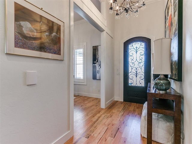 3208 Rolling Woods Dr, Norman, OK 73072 - foyer entrance with ornamental molding, arched walkways, light wood-style floors, baseboards, and a chandelier