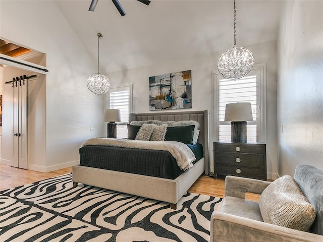 3208 Rolling Woods Dr, Norman, OK 73072 - bedroom with baseboards, light wood-type flooring, lofted ceiling, and an inviting chandelier