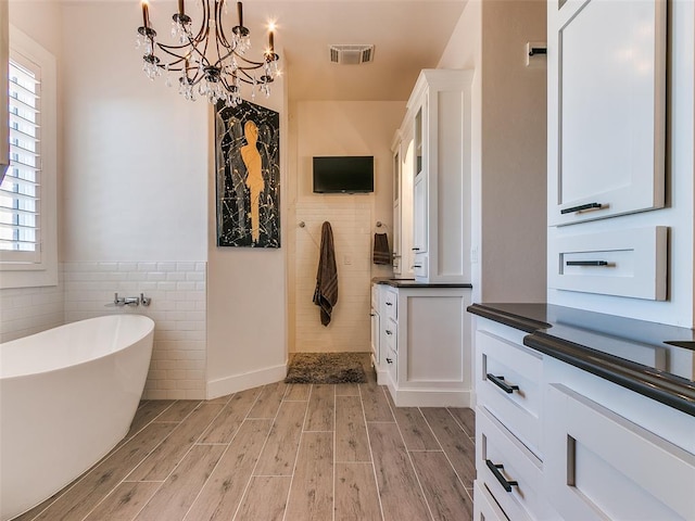 3208 Rolling Woods Dr, Norman, OK 73072 - bathroom with vanity, visible vents, tiled shower, wood finish floors, and a chandelier