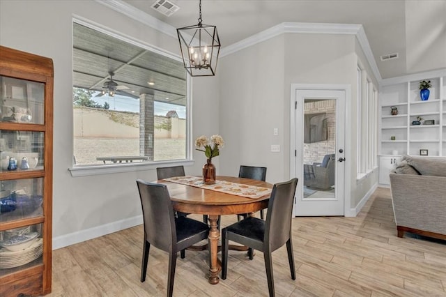 dining space with built in features, ornamental molding, ceiling fan with notable chandelier, and light hardwood / wood-style flooring