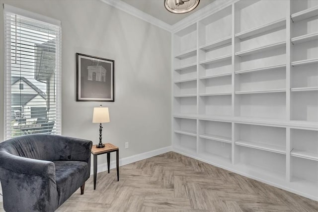 sitting room with built in features, plenty of natural light, ornamental molding, and light parquet flooring