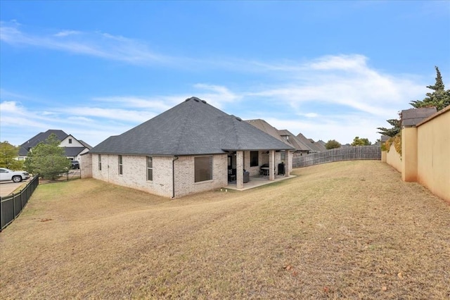 rear view of house featuring a patio and a yard