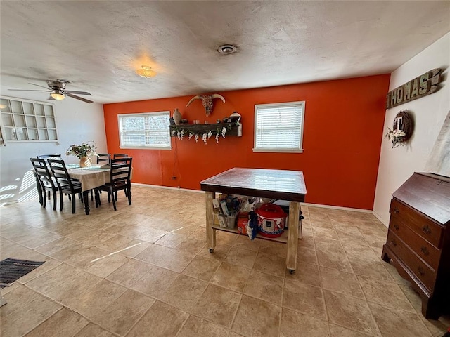 dining area with ceiling fan and a textured ceiling