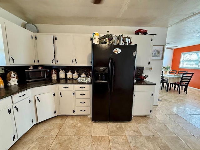 kitchen with white cabinetry, black fridge with ice dispenser, and dark stone countertops