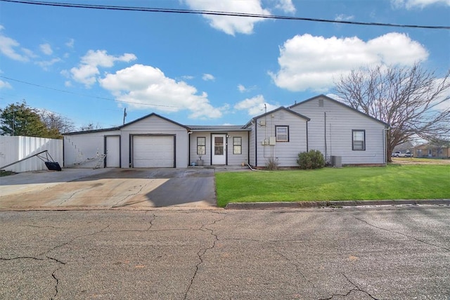 ranch-style house with cooling unit, a garage, and a front yard