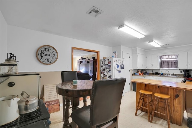 dining room with sink and a textured ceiling