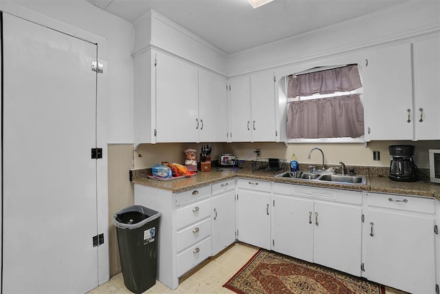 kitchen featuring white cabinetry and sink