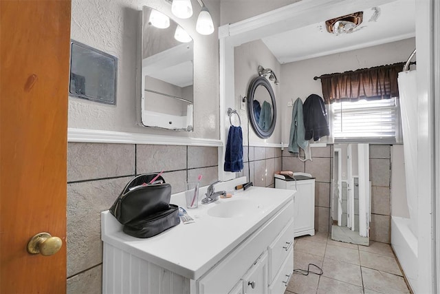 bathroom with vanity, tub / shower combination, tile patterned floors, and tile walls