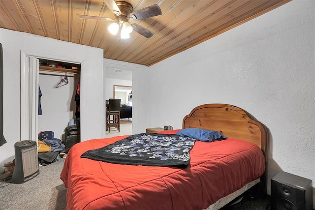 carpeted bedroom with ceiling fan, a closet, and wooden ceiling