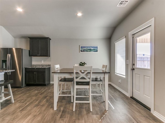 dining room with lofted ceiling and dark wood-type flooring