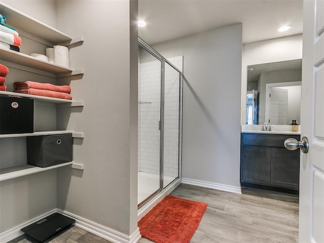 bathroom featuring vanity, a shower with shower door, and hardwood / wood-style floors