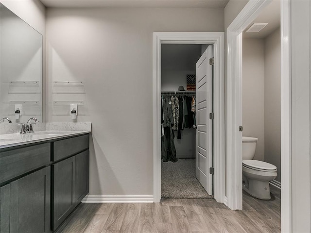 bathroom featuring hardwood / wood-style flooring, vanity, and toilet