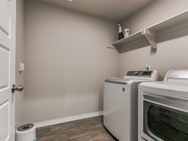 laundry area with dark hardwood / wood-style floors and washing machine and clothes dryer