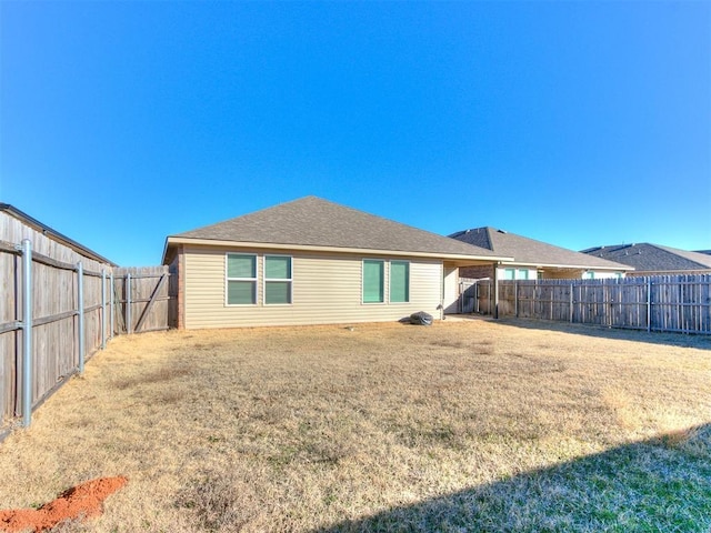 rear view of property featuring a lawn