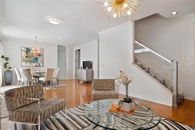 living room with ornamental molding, a chandelier, and light hardwood / wood-style floors