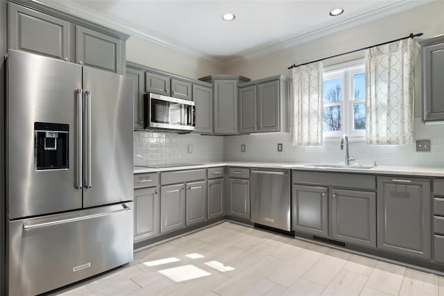 kitchen featuring crown molding, stainless steel appliances, gray cabinets, and sink