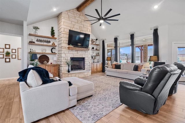 living room with high vaulted ceiling, light wood-type flooring, and a fireplace