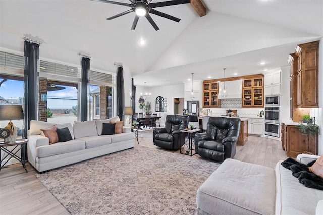 living room featuring ceiling fan, beam ceiling, and light hardwood / wood-style flooring