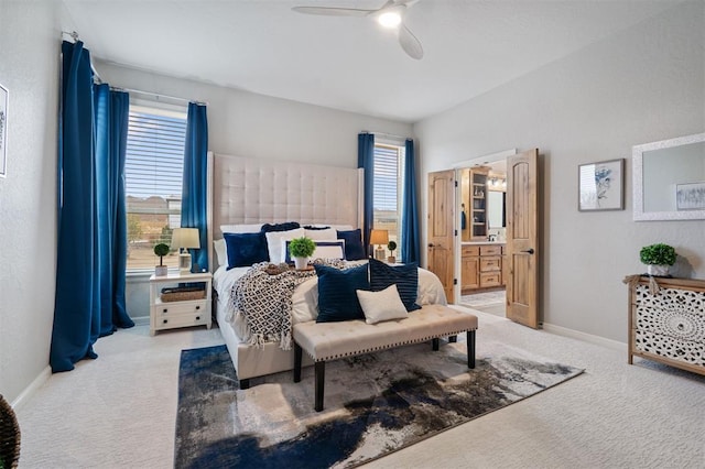 carpeted bedroom with multiple windows, connected bathroom, and ceiling fan