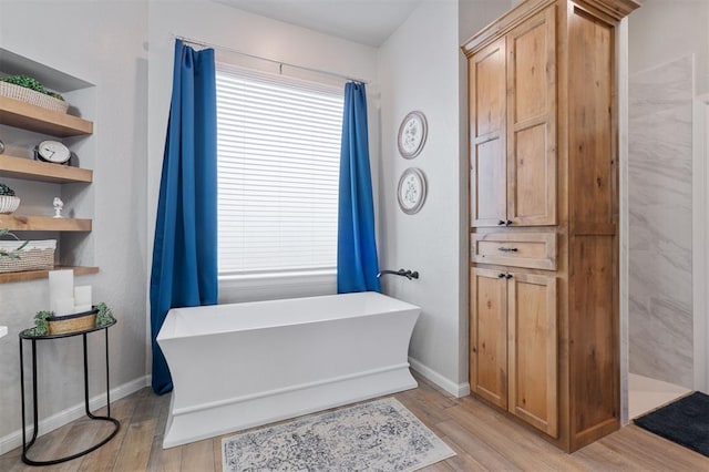 bathroom with hardwood / wood-style floors and a bathtub