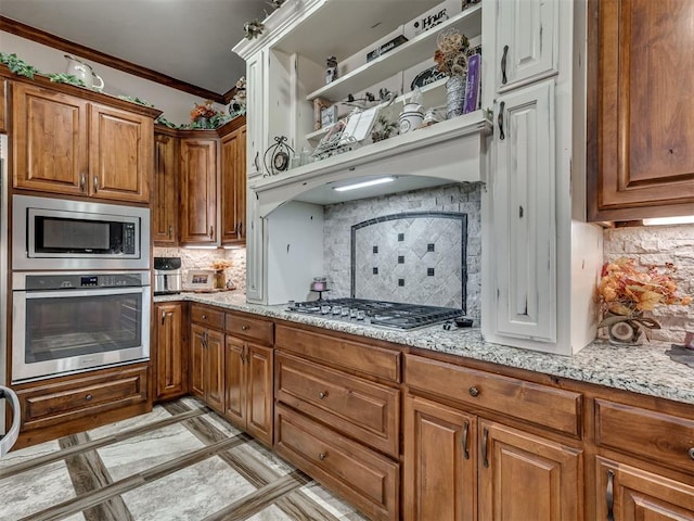 kitchen with light stone counters, appliances with stainless steel finishes, crown molding, and backsplash