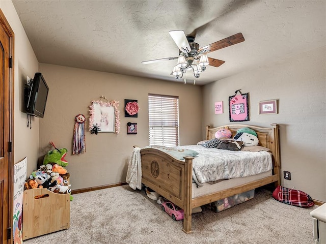 carpeted bedroom featuring ceiling fan and a textured ceiling