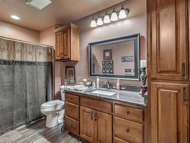 bathroom with vanity, hardwood / wood-style flooring, and toilet