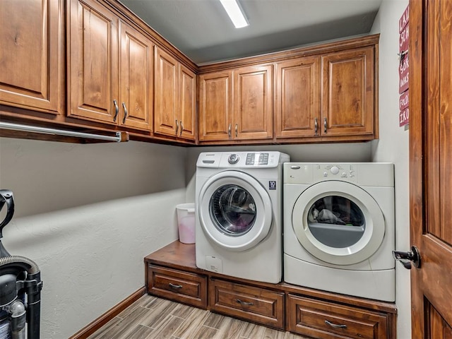 clothes washing area featuring cabinets and washing machine and dryer