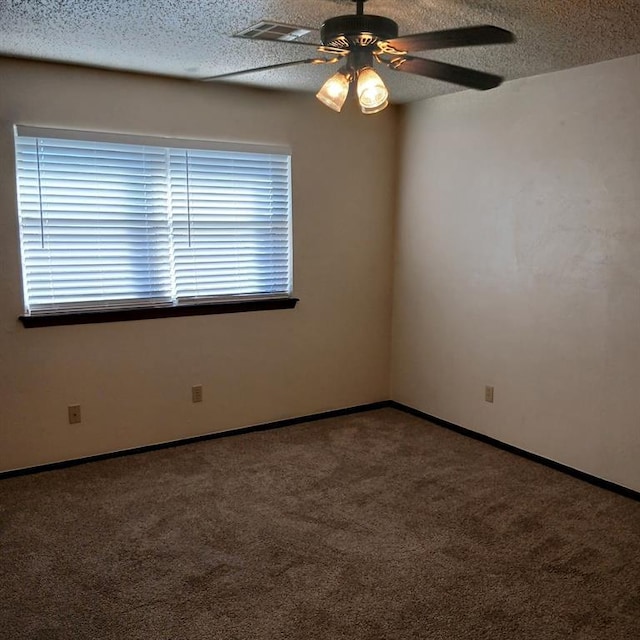 carpeted spare room with ceiling fan and a textured ceiling