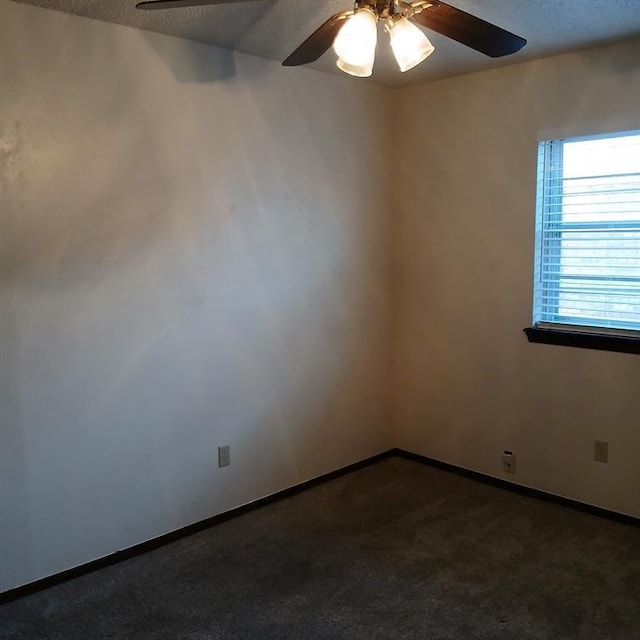 unfurnished room with ceiling fan, a textured ceiling, and dark colored carpet