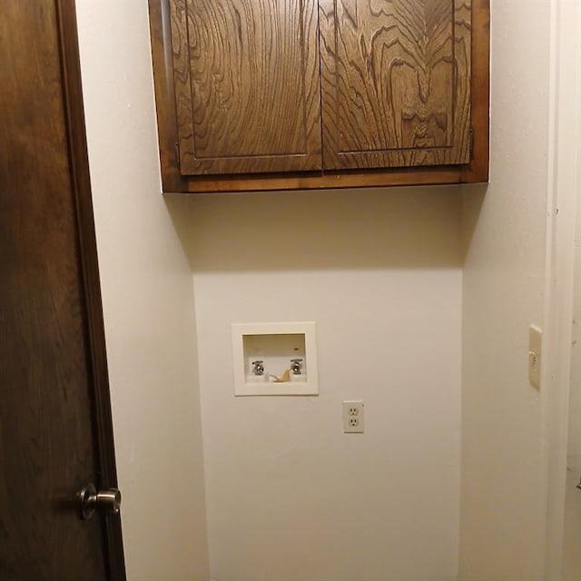 washroom featuring hookup for a washing machine and cabinets