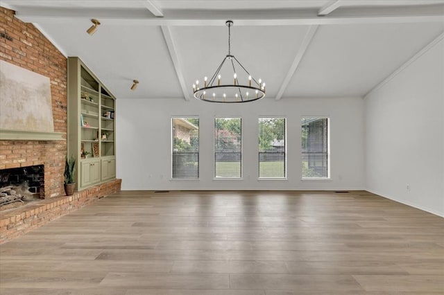 unfurnished living room with a fireplace, lofted ceiling with beams, light hardwood / wood-style flooring, an inviting chandelier, and built in shelves