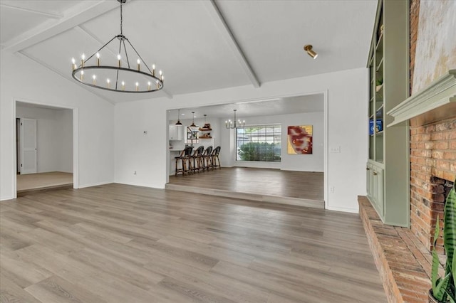 unfurnished living room featuring beam ceiling, an inviting chandelier, high vaulted ceiling, hardwood / wood-style flooring, and a fireplace